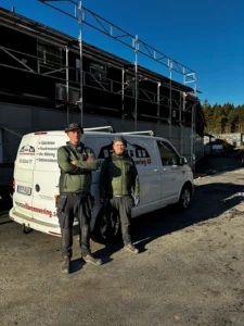 Medarbetare på Wemsa villarenovering framför företagsbil utanför ett pågående takprojekt
